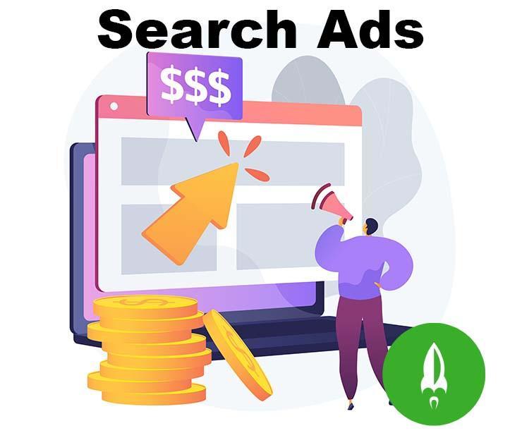 Graphic with a big stack of coins in the forefront, a big yellow arrow pointing to a website shell popping out from a laptop, with a purple conversation bubble positioned above the arrow, filled with dollar signs, labeled Search Ads and with a green Rocket Media logo in the bottom right of the graphic.